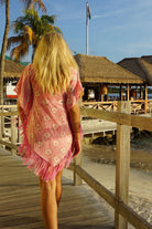 Out and about on Mustique island, walking to Basil's Bar in a pure silk poncho cover-up in coral pink Sand Dollar Crepe-de-Chine by designer Lotty B