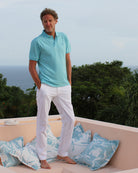 Villa vacation comfortable stretch linen pants worn with pale blue polo shirt. Designer linen resortwear by Pink House 