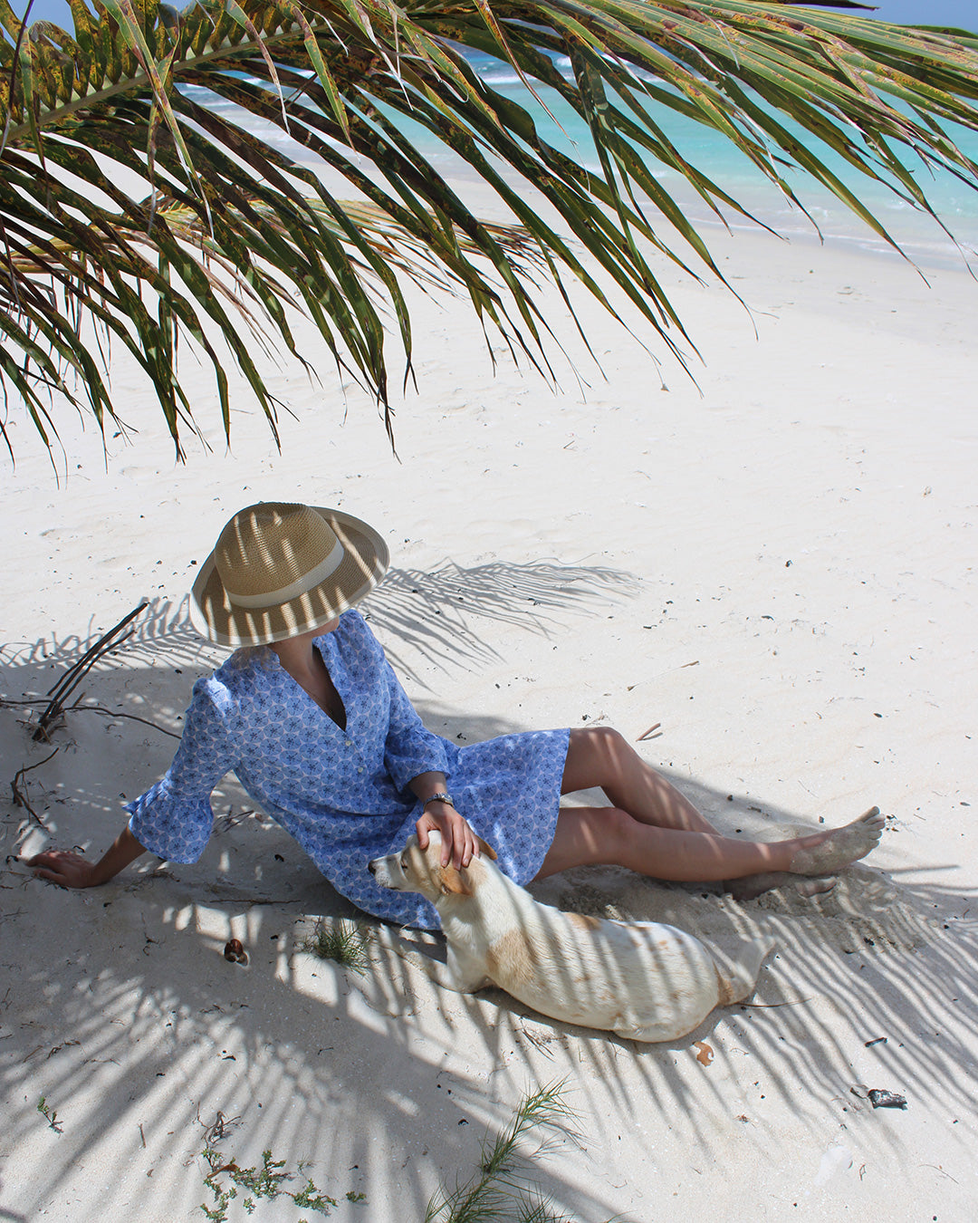 Women's beach vacation dress in blue Sand Dollar print, worn on Lagoon beach with Coco the dog, Mustique Island by Pink House