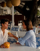 Sundowners at Cotton House beach bar, Mustique styling women's linen vacation dress in blue Sand Dollar print by Pink House