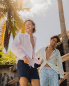 Designer Mustique beach vacation style at Basil's models wearing linen shirts and swim shorts from the Pink House Spring Summer 2025 Pangolin collection