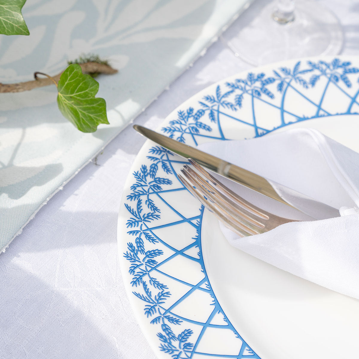 Set the table with fine bone china dinner plates in Palms blue design by Lotty B Mustique