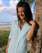 Woman in an elegant linen beach dress in light blue Sealeaf print on Lagoon Bay, Mustique Island