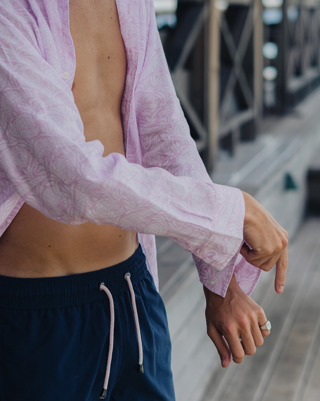 Close up of top quality linen shirt sleeve with mother of pearl buttons in pink Pangolin pattern at Basil's Bar on Mustique Island