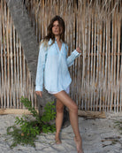 Woman wearing a chic light blue linen shirt in Sealeaf pattern on holiday on Mustique Island