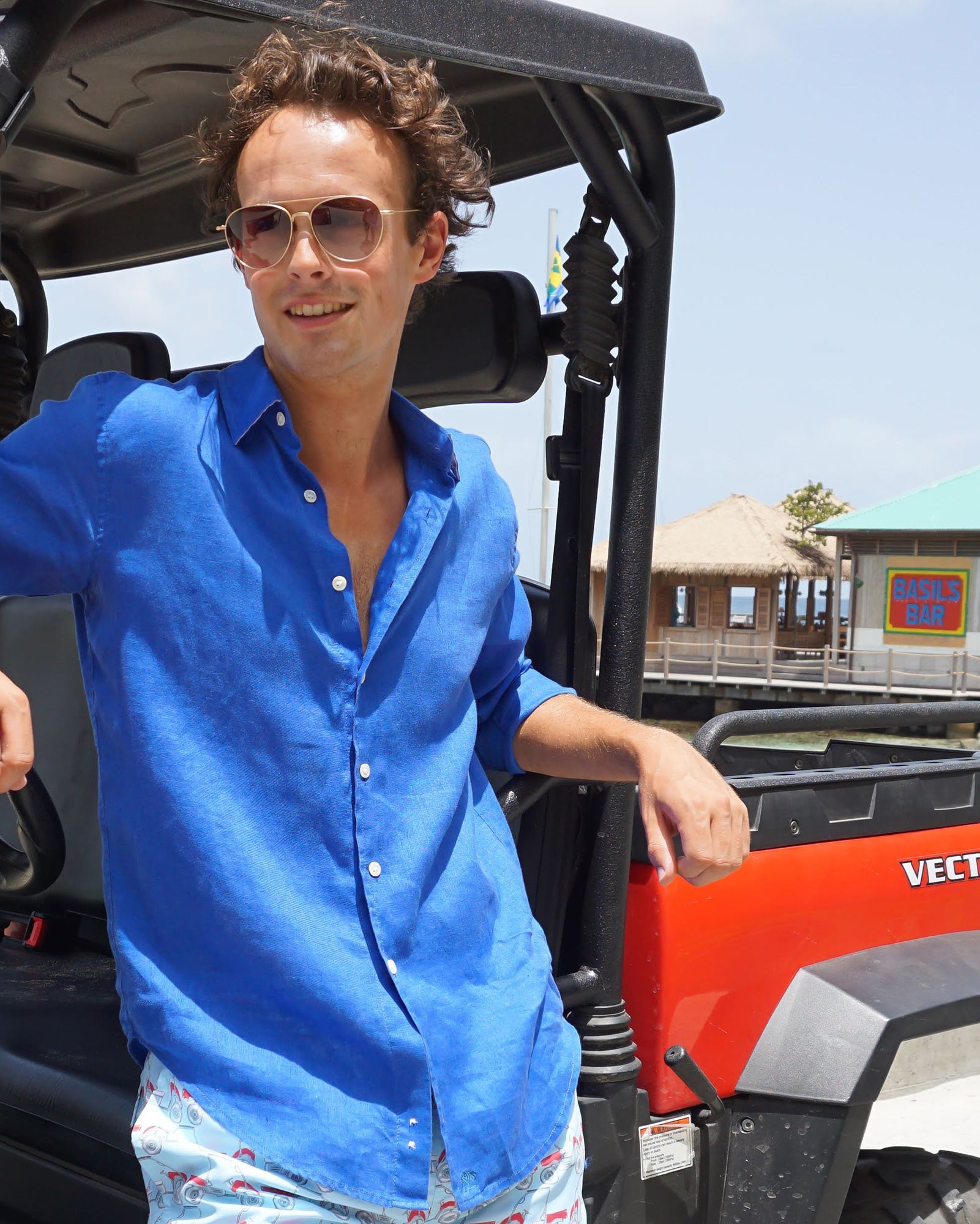 Resort style at Basil's Bar, Mustique island wearing men's linen shirt in dazzling blue