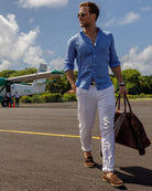 Linen Shirt : FRENCH BLUE, chic Men's style walking across Mustique airport in the West Indies