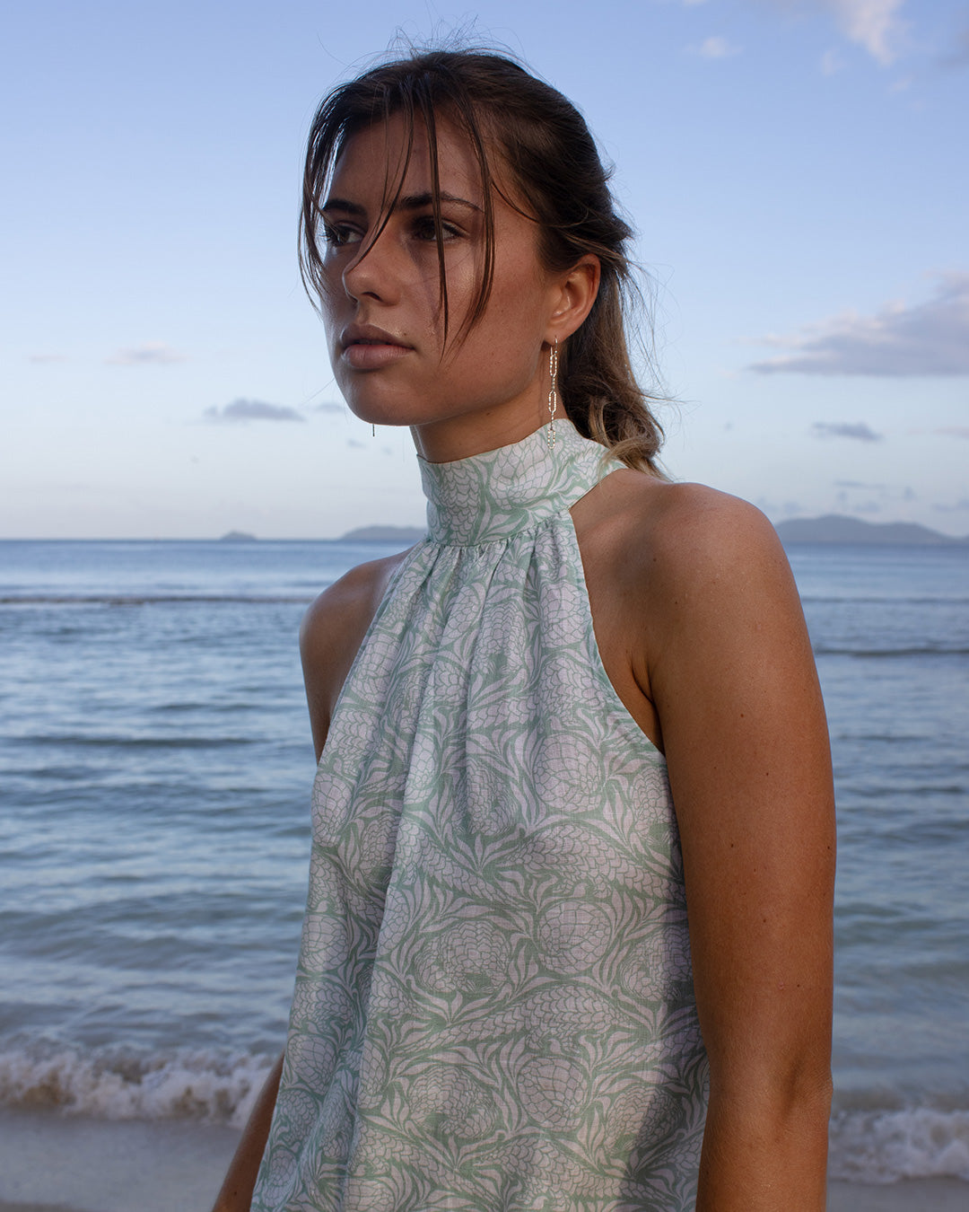 Model Lottie styling the linen Trinny dress in green Pangolin pattern on Dolly beach, Mustique Island.