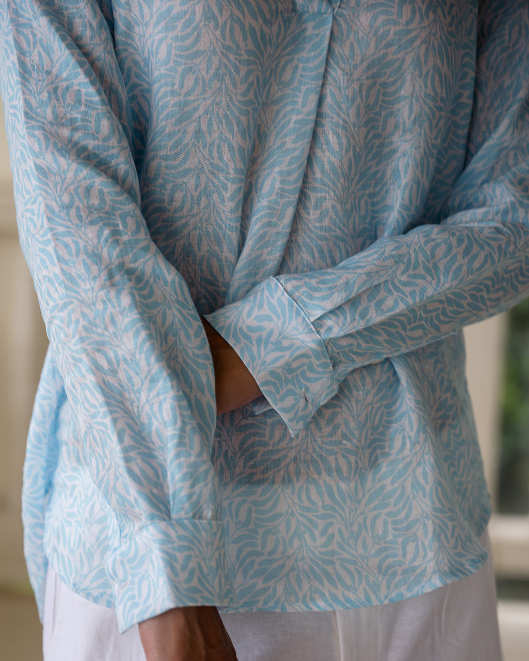 Close up detail showing quality linen shirt sleeves in light blue Sealeaf pattern by resort wear designer Lotty B