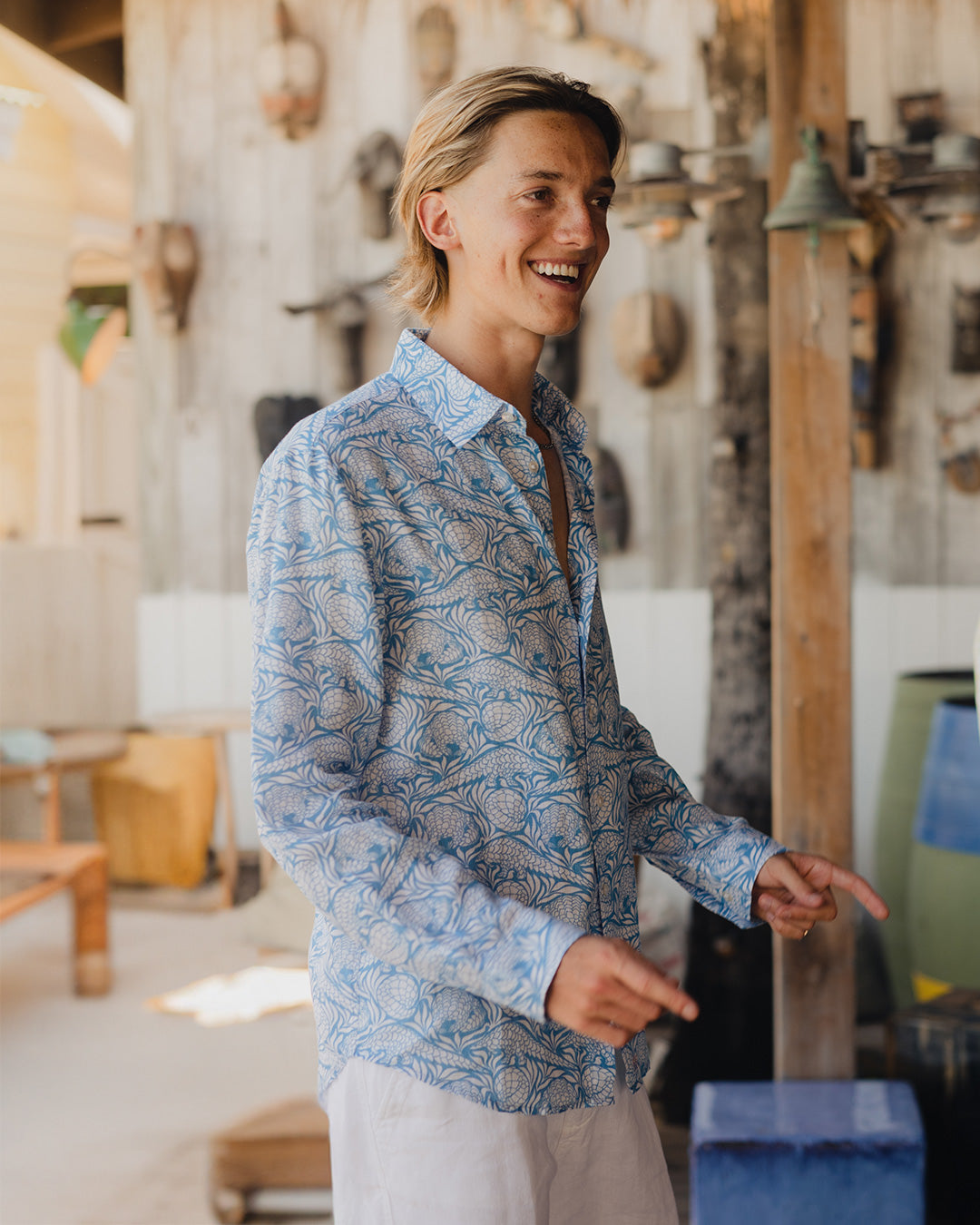 Man wearing a Pink House linen shirt in blue Pangolin pattern at Basil's Beach Bar, Mustique Island