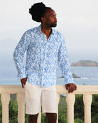 Designer men's plain white linen vacation shorts styled with parrot blue linen shirt