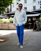 Beach style linen pants in dazzling blue worn with green fern print linen shirt. Resortwear by Pink House 