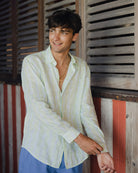 Young man wearing a designer linen shirt in striped green and blue Sealeaf print at Basil's Bar, Mustique Island