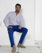 Luxury holiday fashion, linen pants in dazzling blue worn with classic collarless white linen shirt. Resortwear by Pink House 