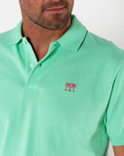 Mens pure cotton green polo shirt with coral pink logo embroidery