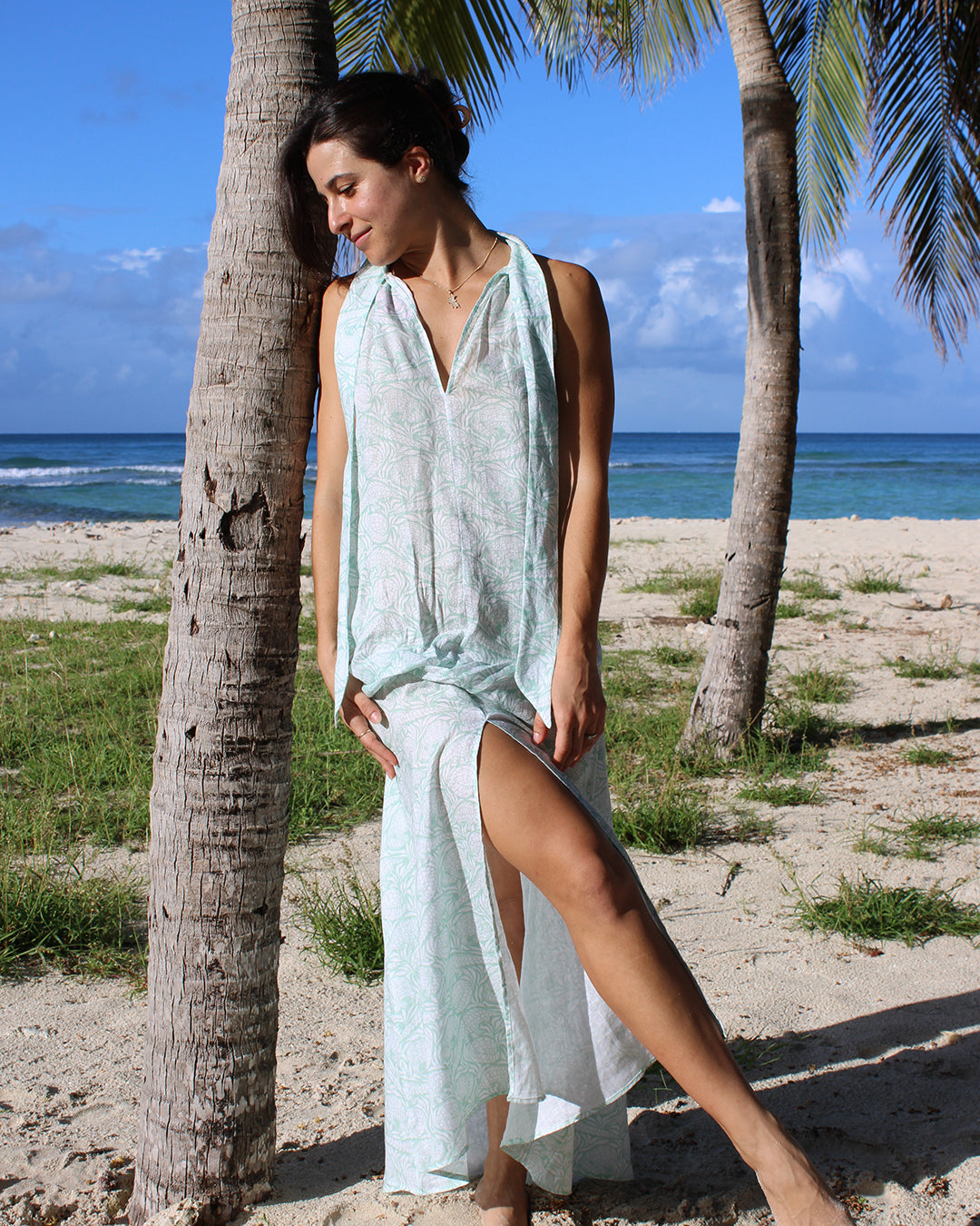 Women's chic beach vacation dress in green Pangolin pattern, worn on Lagoon beach, Mustique Island by Pink House