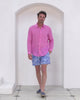 Pink House model Joss wears classic mens recycled, swim shorts in signature blue Toile de Jouy worn with fuchsia pink pure linen shirt