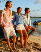 Beach vacation essentials Womens French blue linen shirt paired with classic white linen shorts Pink House Mustique