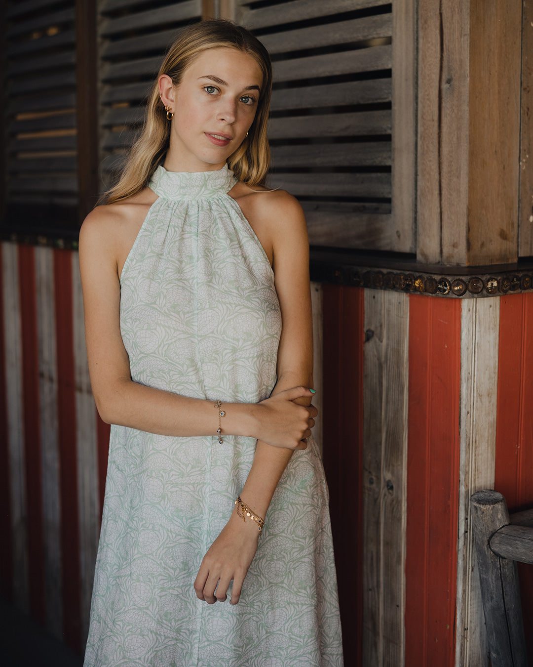 Woman wearing a long linen Trinny dress in green Pangolin design at Basil's Bar, Mustique