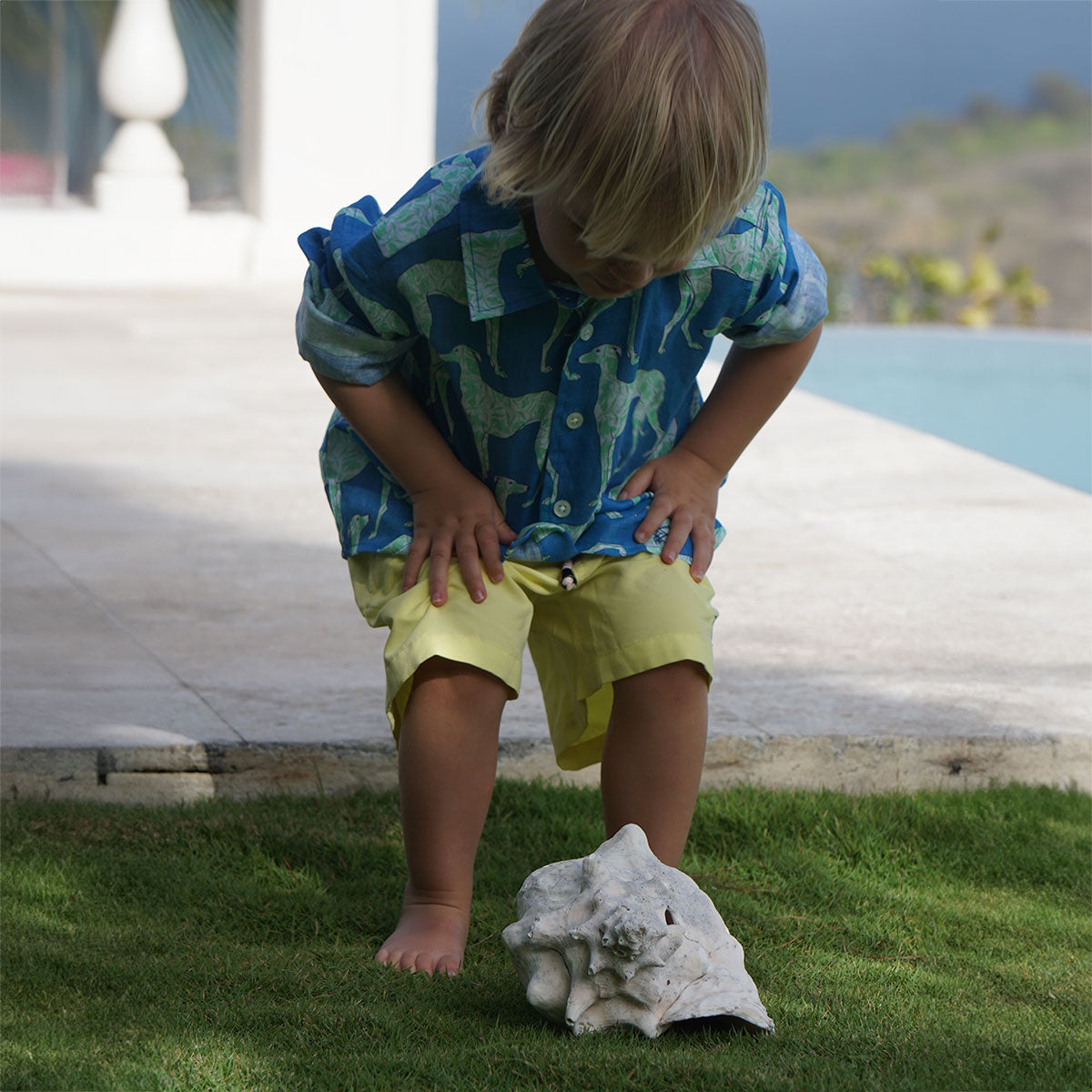 The perfect kid's vacation shirt in Lurcher blue & green print worn with solid yellow swim shorts