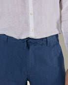 Comfortable drawstring waist casual blue pure linen pants worn with collarless white shirt by Pink House resortwear