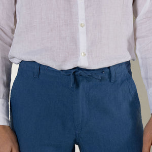 Comfortable drawstring waist casual blue pure linen pants worn with collarless white shirt by Pink House resortwear