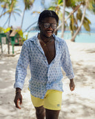 Mustique lifestyle on Lagoon beach in a blue Sand Dollar shirt worn with yellow swim shorts by designer Lotty B for Pink House on Lagoon Bay, Mustique island