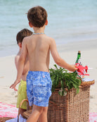 Boys tropical beach swim shorts in blue Pink House Toile print by designer Lotty B